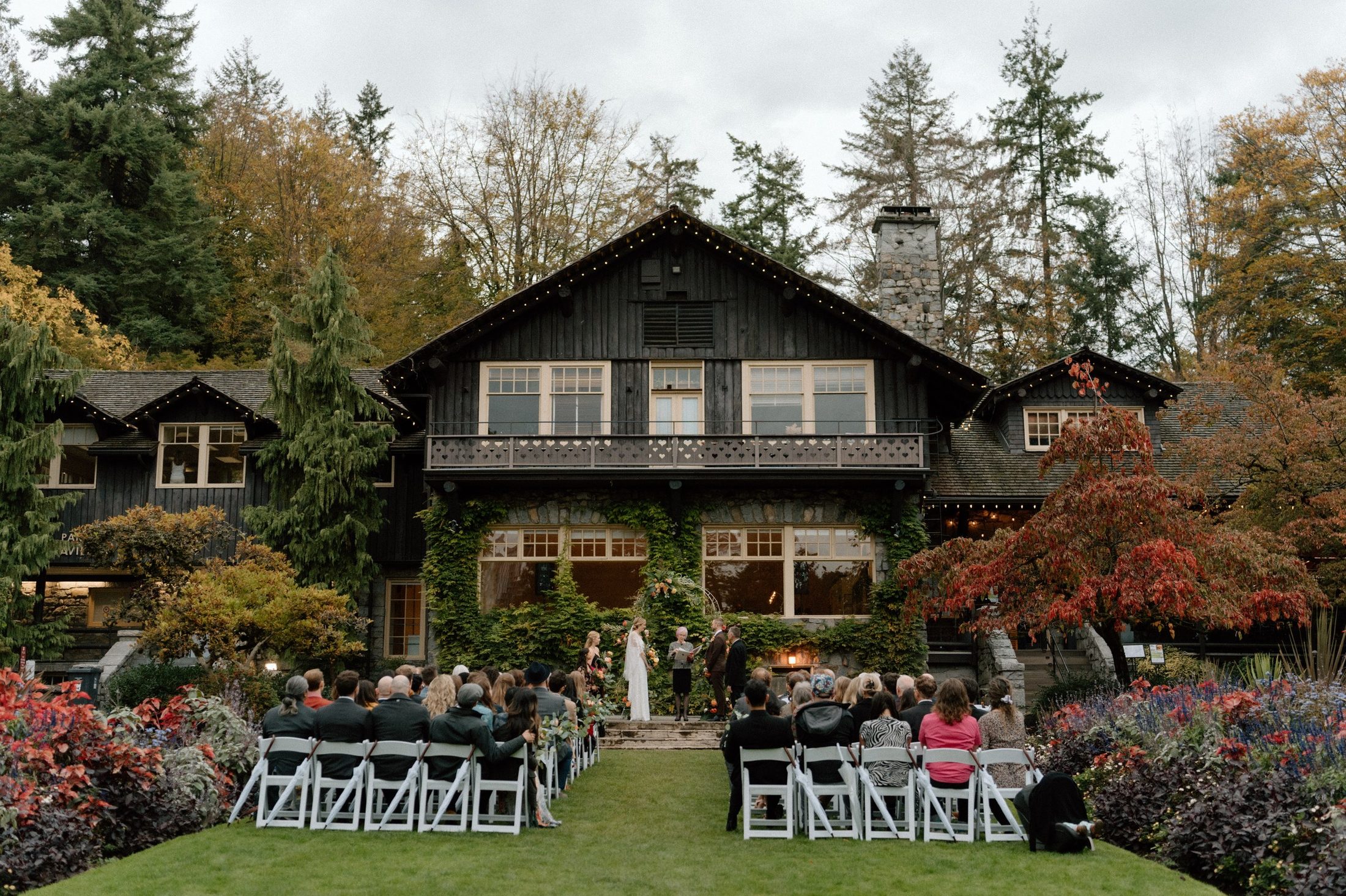An autumn wedding ceremony beneath string lights at a garden estate